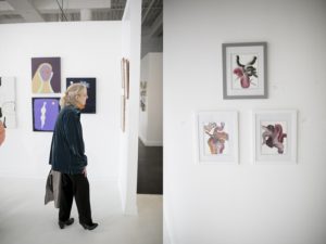 woman walking in front of art gallery wall