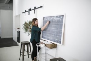 teaching a calligraphy workshop at a chalkboard