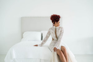 Kayla MaDonna in wedding dress, sitting on white bed