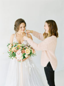 spring bride having her dress adjusted