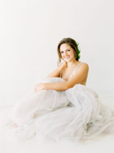 smiling brunette bride sitting on floor