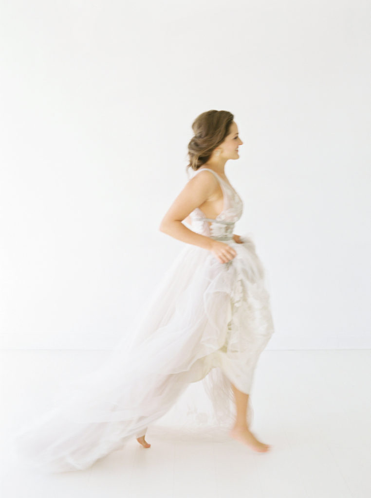 brunette bride walking holding up her dress