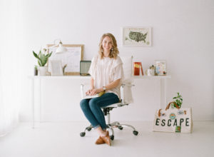 Amanda Olivia sitting in white rolling chair in front of styled desk