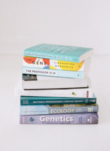 stack of science books in white studio space